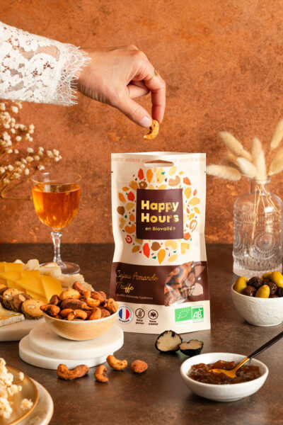 Main saisissant une noix de cajou amande truffe Happy Hours en Biovallée